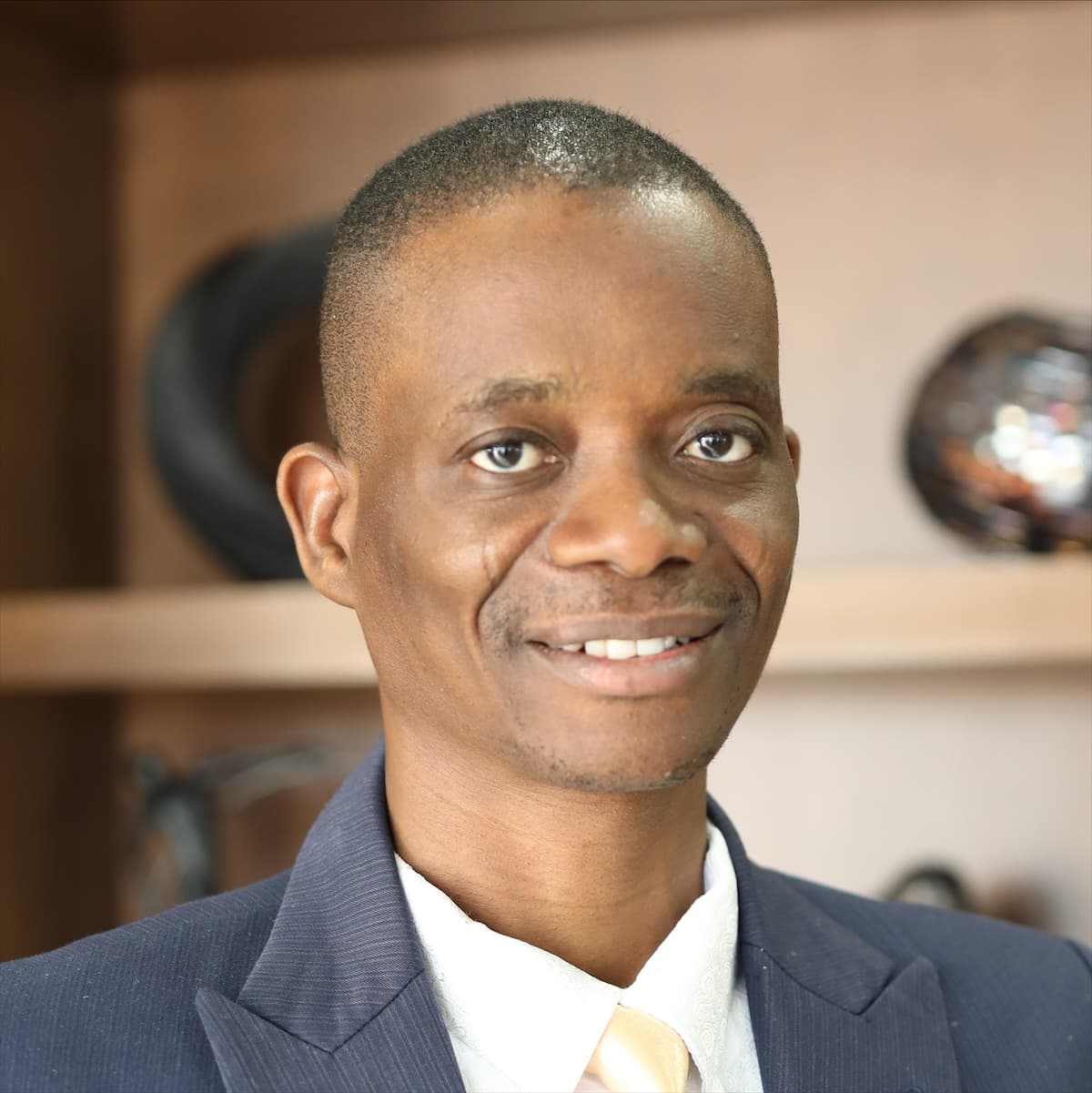 Pastor Israel Sofolahan in a navy suit and gold tie